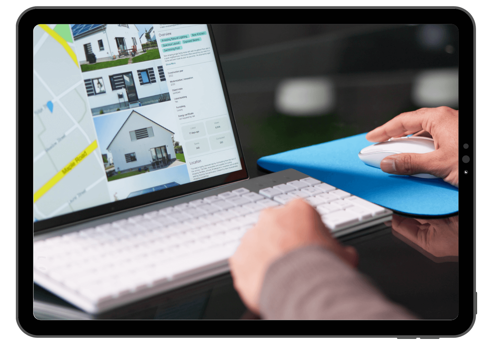 Person browsing real estate listings on a laptop with a keyboard and mouse.