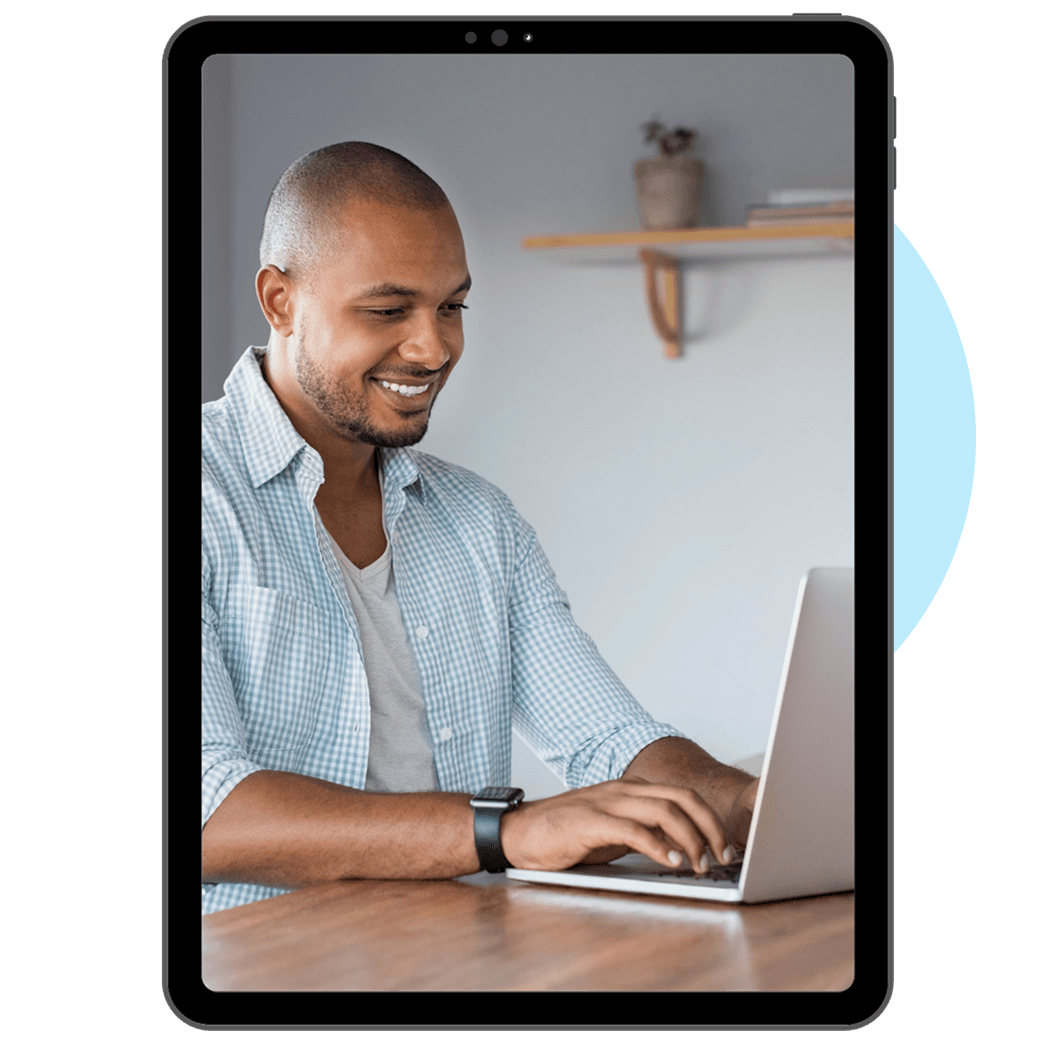 A happy man using his laptop to study courses from Leap Real Estate.